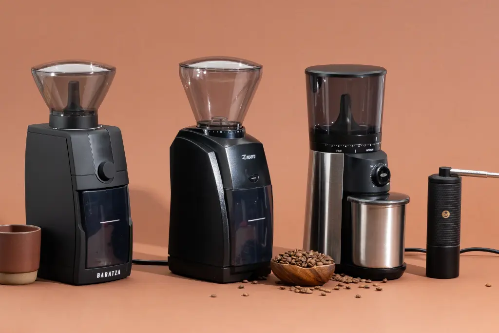 Four burr coffee grinders lined up on a kitchen counter, ranging from budget to premium models.
